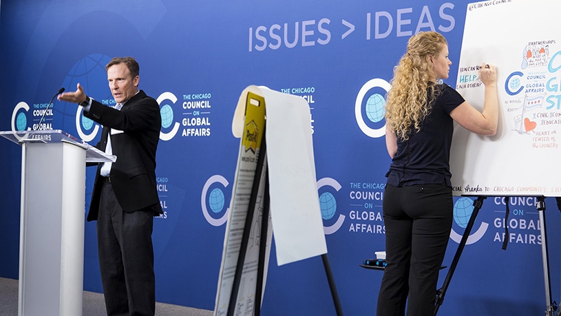 An artist draws visual notes live on stage at the Chicago Council on Global Affairs Keynote