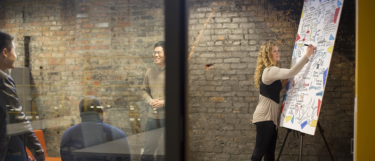 An artist draws a meeting illustration in a small meeting