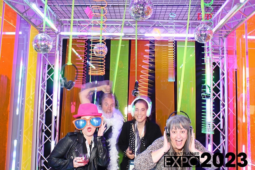 The Ink Factory team takes a silly photo in the photobooth at event planner expo